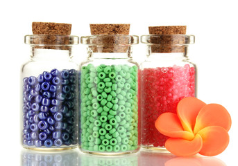 Little bottles full with colorful beads isolated on white