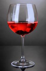 Red wine glass on grey background