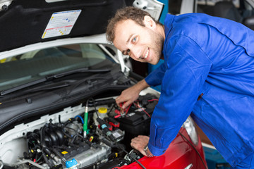 Fototapeta na wymiar Mechanic repairing a car in a workshop or garage