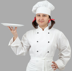 Woman chef holding a white plate