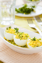 eggs stuffed with greens in a white bowl, snack