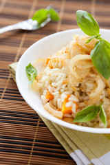Vegetable risotto with pumpkin and onions in a bowl, basil