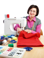 Woman worker sews on the sewing machine.
