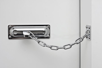 Fototapeta premium the white door is closed on a silvery chain