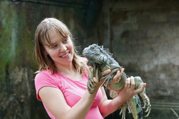 tourist holding iguana