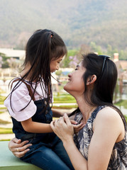 Little asian girl and mom laughing.