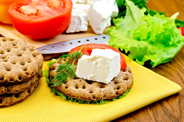 Feta cheese and tomato on a round bread with a knife