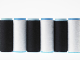 White on white, spools of thread on white background