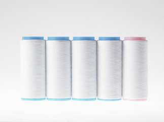 White on white, spools of thread on white background