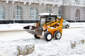 yellow tractor cleaning the snow on a street - 50796548