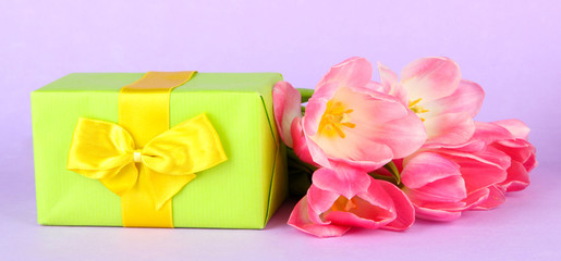 Pink tulips and gift box, on color background