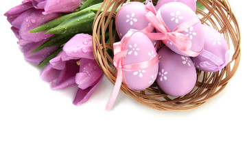 Bright easter eggs in basket and tulips, isolated on white