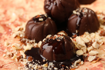 Chocolate candies with nuts, on color background