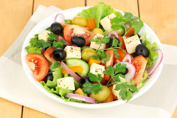 Fresh salad in plate on wooden table