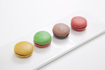 macarons in dish on pink table
