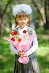 First grader girl posing with bouquet of autumn leaves