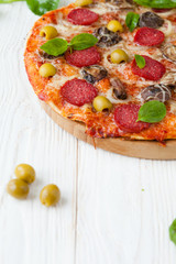 fresh pizza with salami and olives