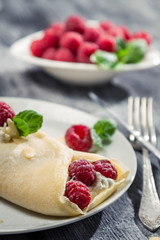 Closeup of raspberry pancakes with almonds and mint leaf