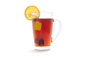 Tea with lemon in a glass cup on a white background. Tea bag