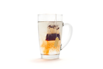 Tea in a glass cup on a white background. Tea bag