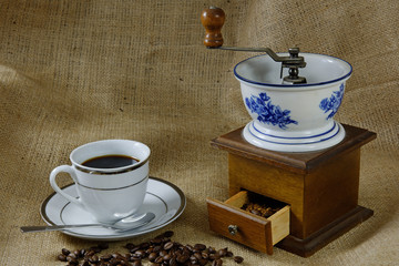 Cup of Coffee with an Antique Coffee Mill