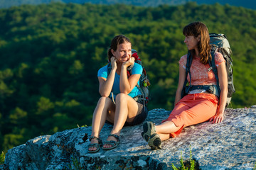 Obraz premium Two trekkers took a rest at the stone in Crimea mountains