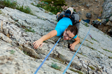 Woman practices in climbing at the rock in the Crimea mountains