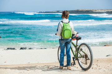 Obraz na płótnie Canvas Dziewczyna z rowerem na plaży