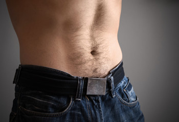 Sporty male belly with jeans closeup photo