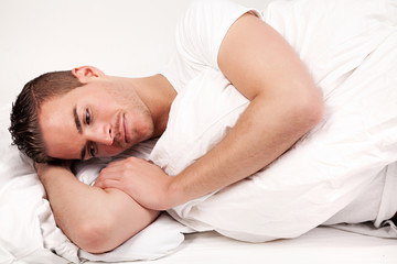 Obraz na płótnie Canvas beautiful young man lying in bed
