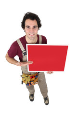 Handyman gesturing towards blank poster