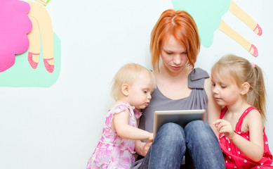 Mother and her daughters using tablet pc