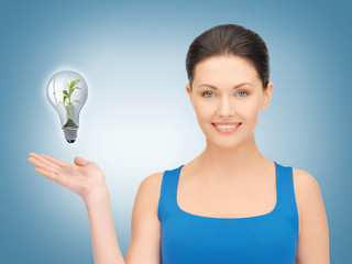 woman showing green light bulb