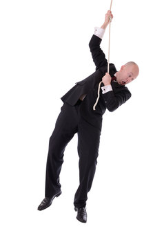 Businessman Hanging On Rope