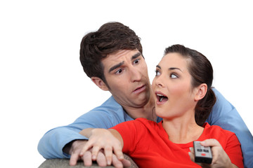 Shocked couple with a remote control
