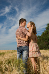 Loving couple kissing on wheat field