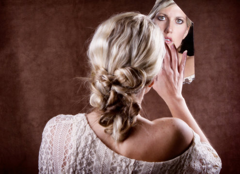 Woman Looking Into A Broken Mirror