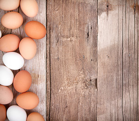 brown and white eggs on a wooden plank
