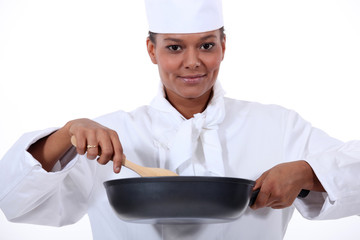 Woman chef stirring a wok