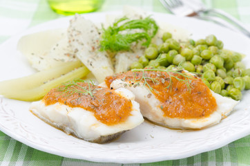 Fish with tomato sauce and vegetables closeup