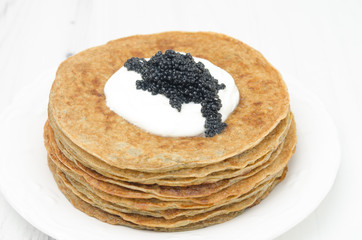 potato pancakes with sour cream and caviar on white background
