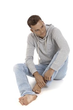 Casual young man sitting on floor