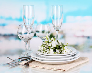 Serving dishes and snowdrops on blue natural background