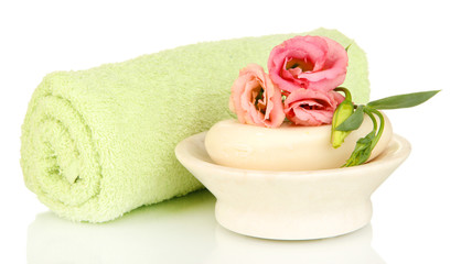 Fototapeta na wymiar Rolled zielony ręcznik, mydła i piękny kwiat wyizolowanych