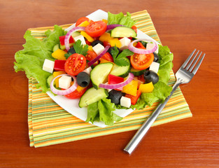 Tasty Greek salad on wooden background