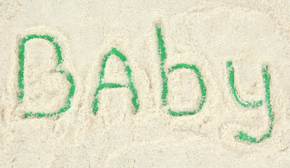 Word baby making with powdered milk on green background