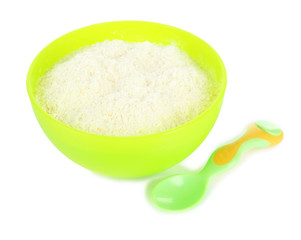Powdered milk in bowl and spoon for baby isolated on white