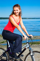Fototapeta premium beautiful woman with bicycle at the sea