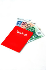 Rotes Sparkassenbuch, in dem sich Geldscheine befinden..