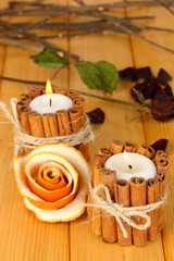 Fototapeta na wymiar Decorative rose from dry orange peel and burning candles